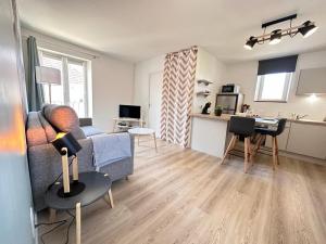 a living room with a couch and a kitchen at Au nid du clos cocon a la campagne 10min de Reims in Courcelles-Sapicourt +23 photos