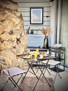 a table and chairs in a room with a stone wall at Sunny Home Costa Plana-Monaco -Cap D'Ail in Cap d'Ail