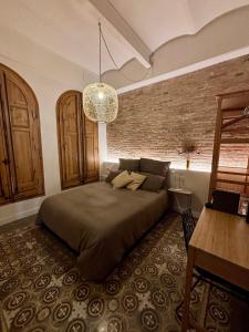 ein Schlafzimmer mit einem Bett und einer Ziegelwand in der Unterkunft Cozy Suite in a historic house near the sea in Vilanova i la Geltrú