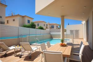 a patio with a table and chairs and a swimming pool at Seaview Luxury Villa Jacuzzi & Pool! 2 Min Beach in Protaras