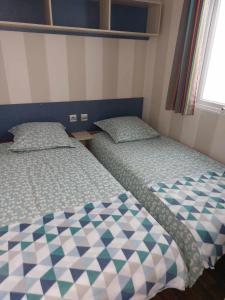 two beds in a small room with at Gaby mobil Home in Port-la-Nouvelle