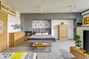 a hotel room with a bed and a tv at Mini Paradise Apartment by tisyastays in Candolim +19 photos