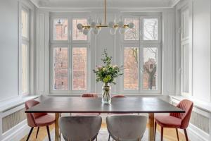 een eetkamer met een tafel en stoelen en een vaas met bloemen bij Blue Mandarin Old Town in Gdańsk +32 foto's
