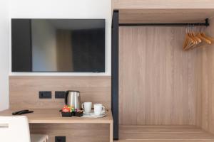 una stanza con una tv e un mobile in legno di Hotel Maiuri Pompei a Pompei