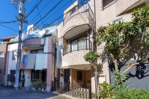 um edifício de apartamentos com uma varanda numa rua em 121T MINE HOME野方 nogata MH野方 98m貸切 野方駅から徒歩1分 新宿まで6駅17分 寝室4 広々一軒家 リノベーション em Tóquio
