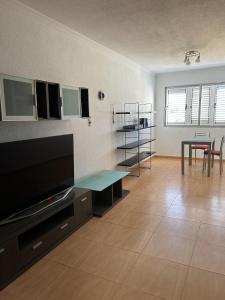 ein Wohnzimmer mit Flachbildfernseher und einem Tisch in der Unterkunft EstrellaMar in Arinaga