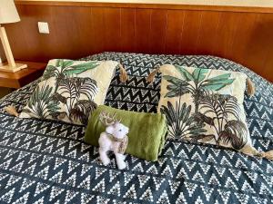 a stuffed animal is sitting on a bed with pillows at nid douillet au milieu des pins entre lac et océan in Carcans