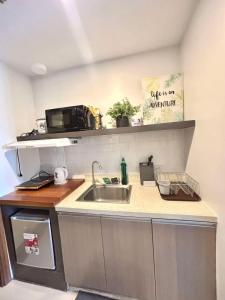 a kitchen with a sink and a microwave at Horizons 101 Fab Condotel in Cebu City