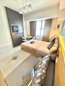 a bedroom with a large bed and a living room at Horizons 101 Fab Condotel in Cebu City