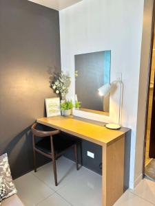 a desk with a mirror and a chair in a room at Horizons 101 Fab Condotel in Cebu City +1 photo