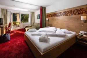 Postel nebo postele na pokoji v ubytování Alm- & Wellnesshotel Alpenhof + 37 fotografií