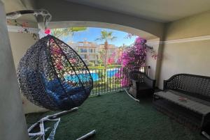 a room with a swing and a balcony with a pool at Studio with stunning view in Vernada Sahl Hasheesh in Hurghada +12 photos