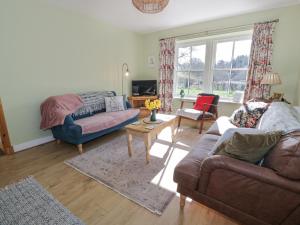 ein Wohnzimmer mit zwei Sofas und einem Tisch in der Unterkunft Morton Mains Steading Cottage in Thornhill