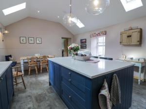 eine Küche mit blauen Schränken und einem Esszimmer in der Unterkunft Morton Mains Steading Cottage in Thornhill