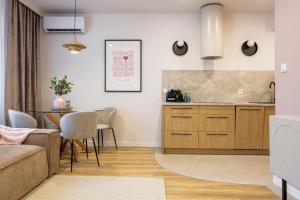 a kitchen and living room with a couch and a table at Comfy Aparts Św Mikołaja in Głogów
