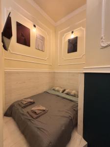 a bed in a room with pictures on the wall at City Hall Flat in Ioannina