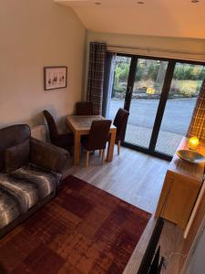 a living room with a couch and a table at Millstone Stables Cottage in Chinley