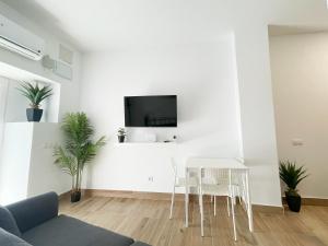 Una sala de estar blanca con una mesa y sillas blancas. en Cerca del centro y luminoso, en Madrid