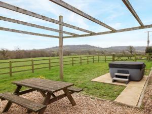 einen Picknicktisch und eine Badewanne auf dem Feld in der Unterkunft Daisy Cottage in Bridport