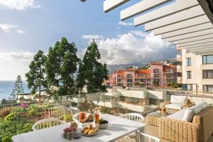 Un apartamento con balcón con mesa y sillas. en Acqua Residence II by An Island Apart, en Funchal