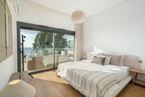 Un dormitorio blanco con una cama y una ventana grande. en Acqua Residence II by An Island Apart, en Funchal 50 fotos más