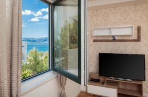 a living room with a tv and a large window at Villa ARIJANA 2 in Slatine