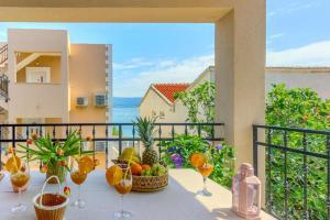 a table with fruit and wine glasses on a balcony at Villa ARIJANA 2 in Slatine
