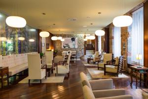 a waiting room with chairs and tables and lights at Hotel Balneario La Hermida in La Hermida