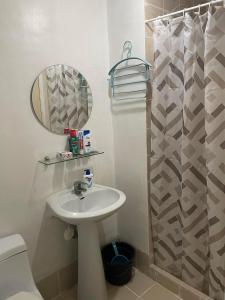 a white bathroom with a sink and a shower at Xian's place Budget Friendly Condo in Manila