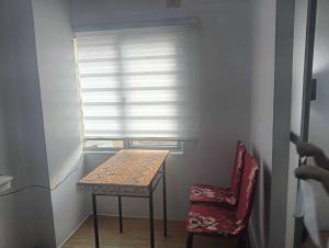 a table and a chair in a room with a window at Xian's place Budget Friendly Condo in Manila +3 photos