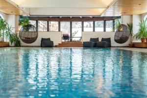 a swimming pool with blue water in a hotel at Home's am Hof in Nauders