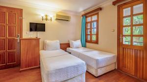 a hotel room with two beds and a tv at Perdikia Beach in Oludeniz