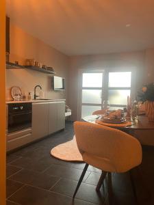 a kitchen with a table and a dining room at Zon & blij in Katwijk aan Zee