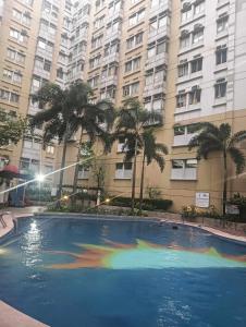 a large swimming pool in front of a large building at Xian's place Budget Friendly Condo in Manila