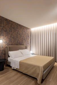 une chambre avec un grand lit avec une grande fenêtre dans l'établissement Le Due Erre Home Boutique, à Agrigente