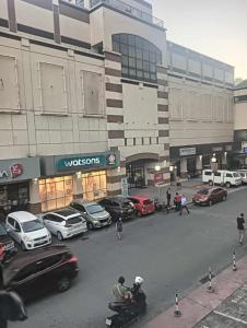 a city street with cars parked in front of a building at Xian's place Budget Friendly Condo in Manila +3 photos