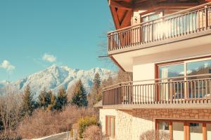 a building with a balcony and mountains in the background at Das Gsteig in Garmisch-Partenkirchen