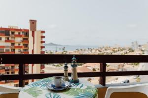 a table with a cup of coffee on a balcony at Hotel Apartamentos Londres La Manga in La Manga del Mar Menor