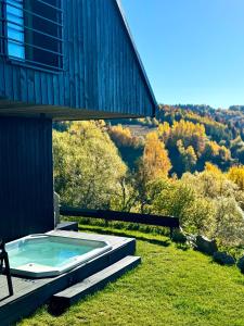 a hot tub sitting on the side of a house at Bacówki Resort in Ochotnica Górna