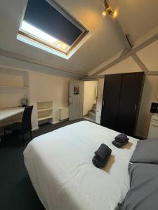 Un dormitorio con una cama grande con dos toallas negras encima. en Appartement 6 personnes, en Vierzon