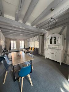 sala de estar con mesa de madera y sillas azules en Appartement 6 personnes, en Vierzon