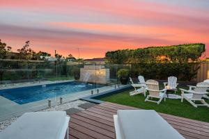 雪莉海滩Luxury Beach House - Heated Private Pool & Heated Spa - Fire Pitt - Walk to Beach & Golf的一个带桌椅的庭院和一个游泳池
