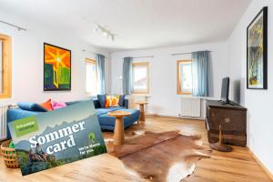 un soggiorno con un divano blu e una TV di Apartments Sopherl - by myNests ad Aich