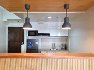 a kitchen with white cabinets and a black refrigerator at Newly Furnished Condominium in the Heart of Quezon City near Top Philippine Hospitals in Manila