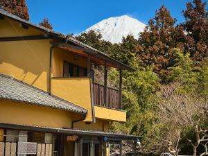 富士宫市Shiraito Garden A Private Retreat Near Shiraito Falls with Mt Fuji Views的带阳台的建筑,背景是山脉