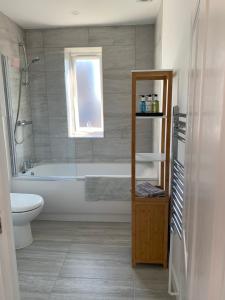 a bathroom with a tub and a toilet and a sink at Fort View- Totland in Totland +34 photos