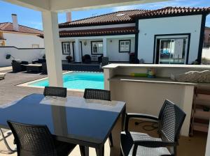 a patio with a table and chairs and a swimming pool at Spacious quiet charming villa with private pool and close to Lisbon in Monte de Lucas