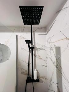 a black floor lamp in a bathroom with marble walls at La Cachette in La Grande-Motte +12 photos