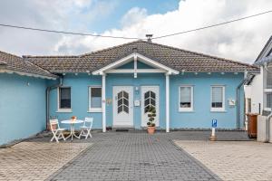 a blue house with a table and chairs in front of it at Ferienwohnung mit Aussicht in Notscheid