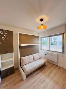 a living room with a couch and a window at La Cachette in La Grande-Motte